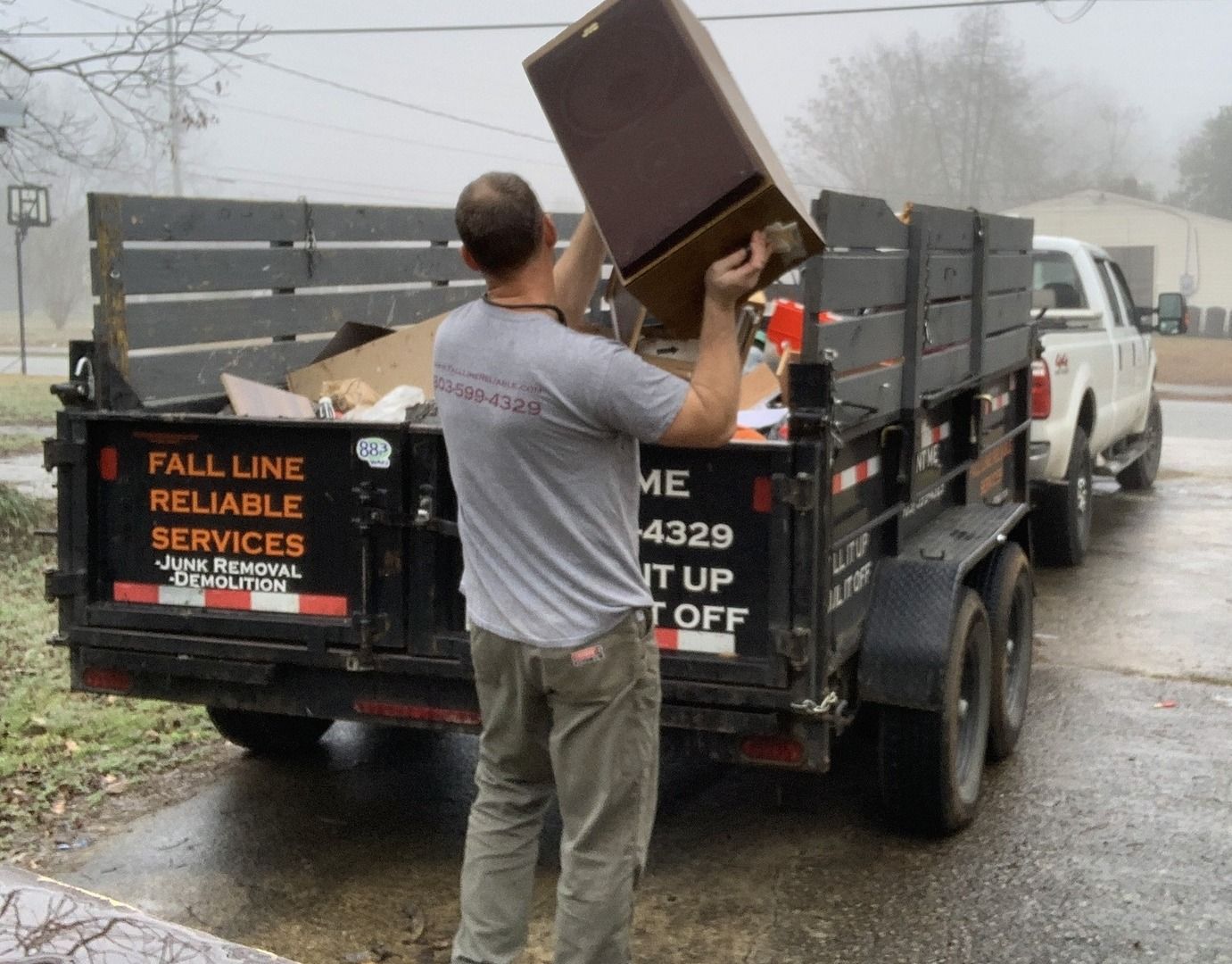 Loading yard and outdoor debris into a rental dumpster trailer in Aiken SC